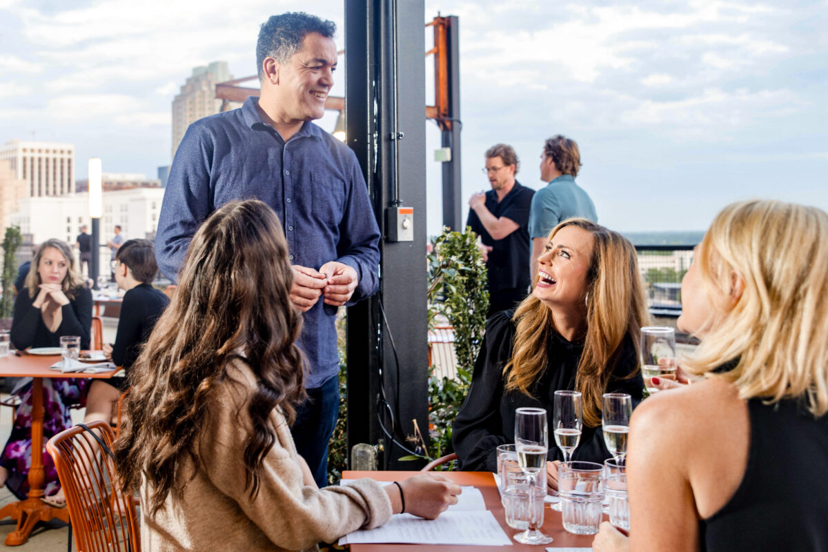Samad talking with Raleigh Magazine table at La Terrazza Rooftop